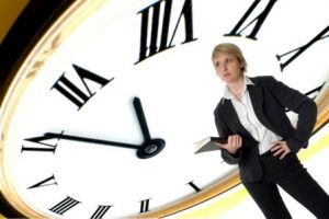 business woman standing with clock in background concept